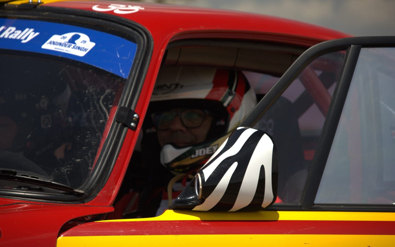 Driver helmeted and strapped in behind the roll cage, waiting for the off