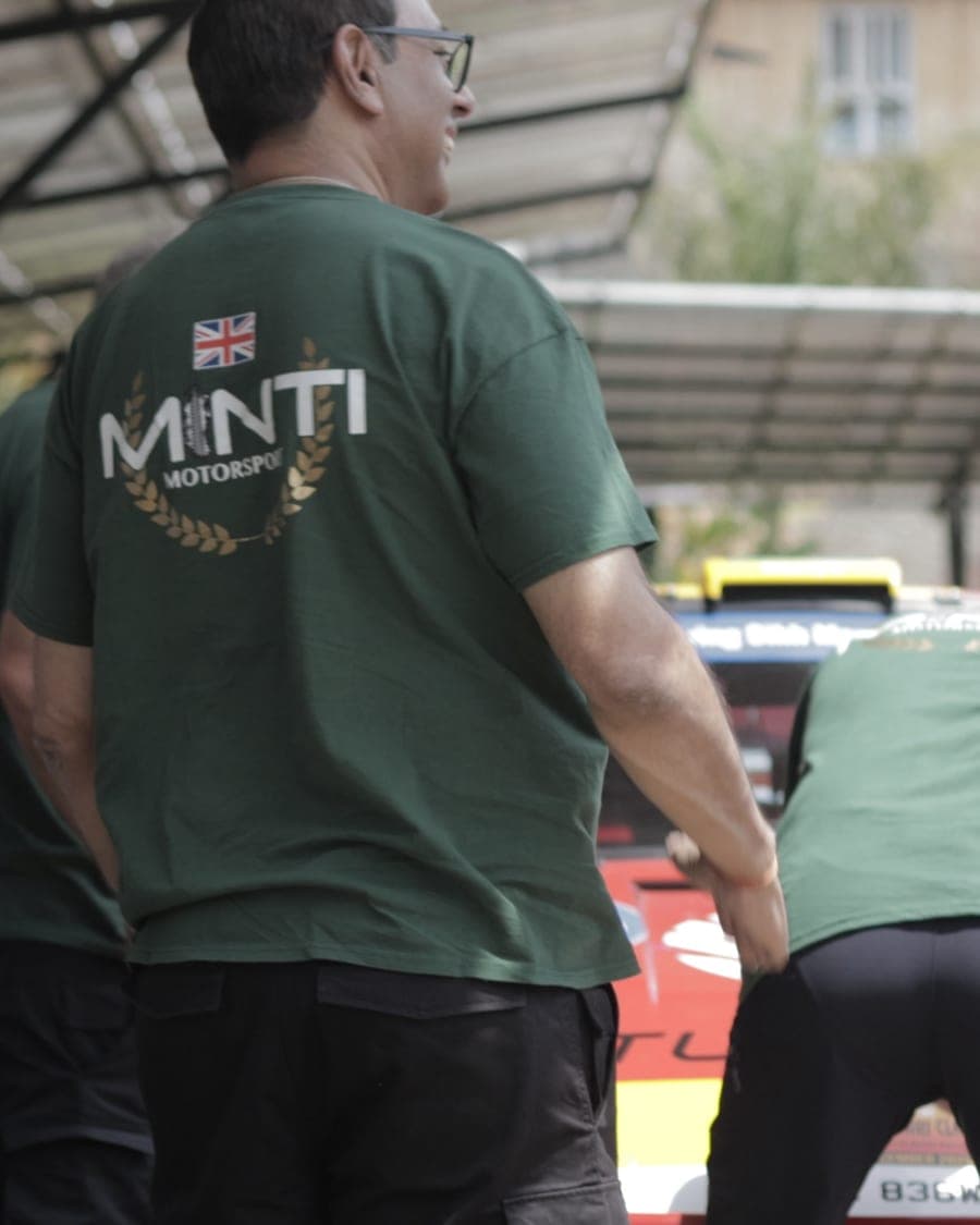 Minti crew in team shirts working over the car at service